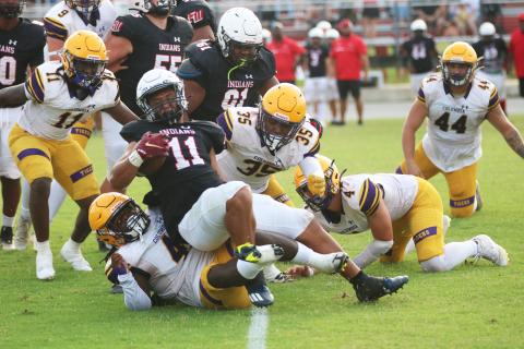 Fort White running back Lecosta Byrd is tackled by Columbia defensive lineman Terry Henry during Friday’s spring game. (JORDAN KROEGER/Lake City Reporter)