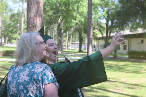 Jennifer Chaplin (from left) and her daughter Chloe Chaplin take a selfie with Chloe’s cell phone after Chloe graduated from Florida Gateway College on Friday morning at the Howard Center. (TONY BRITT/Lake City Reporter)