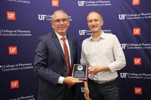 Dr. Richard Nabinger, pharmacist at the Baya West Pharmacy, receives the Advanced Pharmacy Practice Experience Outpatient Preceptor of the Year award from Peter Swaan, dean of the University of Florida College of Pharmacy, at the college’s graduate awards celebration Friday. (COURTESY UF COLLEGE OF PHARMACY)