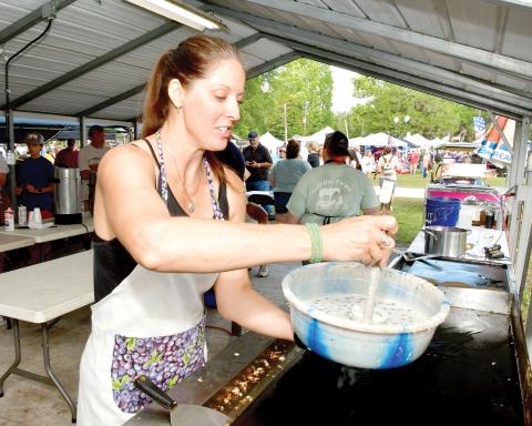 A volunteer readies to make blueberry pancakes at last year’s Wellborn Blueberry Festival. (FILE)