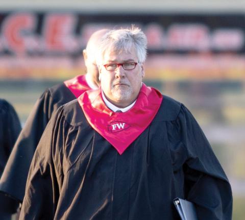 Fort White High Principal Keith Couey walks on to the Arrowhead Stadium field last month for graduation. Couey is being moved to the district office as he prepares to be the district superintendent. (RAY CARPENTER/Special to the Reporter)