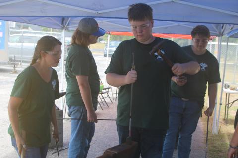 Logan Haley hammers on a metal rod during the Forged in 4-H Blacksmith camp while Erin Harlow, a Columbia County extension agent, looks on. (TONY BRITT/Lake City Reporter)