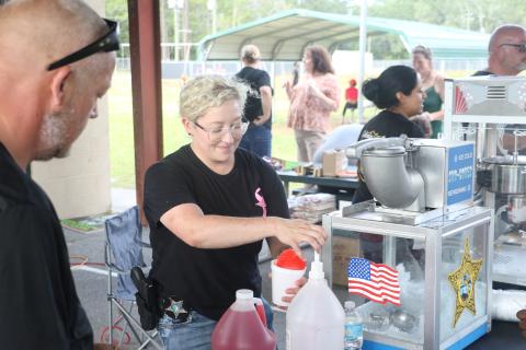 Jessica Chewning, a school resource deputy at Westside Elementary School, prepares a snow cone for a kid during Friday’s Summer Nights activities at Five Points Elementary. (MORGAN MCMULLEN/Lake City Reporter)