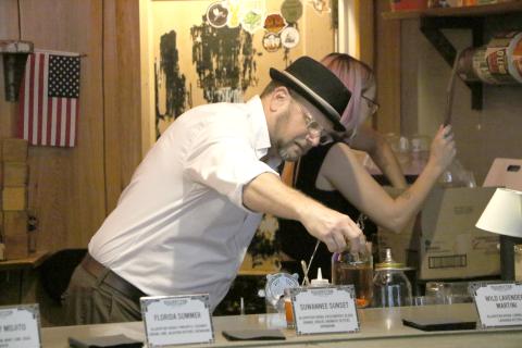 Halpatter Brewing Company co-owner Chris Candler sets down a bottle of distilled spirits during Tuesday’s soft launch of the company’s new line of liquors. (MORGAN MCMULLEN/Lake City Reporter)