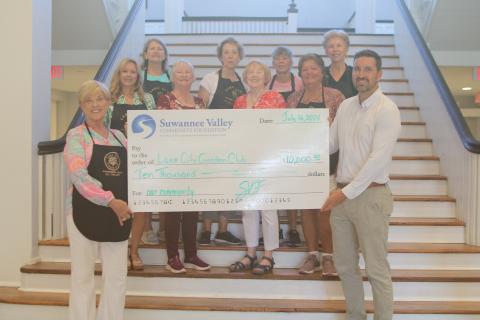 Tina Roberts (front row, from left) stands with other Lake City Garden Club members, as she and Patrick Douglas, of the Suwannee Valley Community Foundation, hold a $10,000 check that was presented to the organization on Wednesday at the Blanche Hotel. Other Garden Club members present include, Ginger McCrannie (second row from left), Cheryl Libert, Kathy Smith and Mary Victores; Jan Logan (back row, from left), Terri Johnson, Sonya Rossin and Dorothy Colvin. (TONY BRITT/Lake City Reporter)