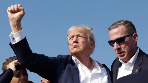 Republican presidential candidate former President Donald Trump pumps his fist as he is rushed offstage during a rally on Saturday in Butler, Pennsylvania. (ANNA MONEYMAKER/Getty Images)