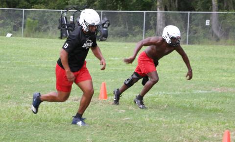 Fort White linebackers Lecosta Byrd (left) and David Harps run drills at Tuesday’s practice before it was called due to lightning and rain. (MORGAN MCMULLEN/Lake City Reporter)