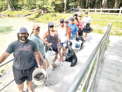 Billy Golightly (from left), Jennifer Golightly, Sandy Kishton, Missy Zecher, Becky Smallwood, Angela Cox, Rhaiza Faulkner, Ginny Smith and Lynda Granoff pose for a photograph after spending time participating in a recent cleanup effort at Rum Island Park. (COURTESY)