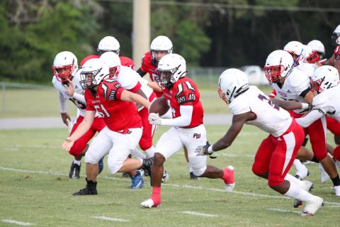 Fort White running back Keimarion Neal bursts through the NFEI defense during Thursday's Preseason Classic. (MORGAN MCMULLEN/Lake City Reporter)