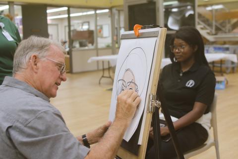 Dino Casterline draws a caricature of Chans Barner on Monday afternoon during Florida Gateway College’s first day of classes for the fall semester. (TONY BRITT/Lake City Reporter)