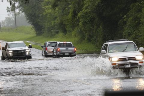Vehicles drive through flood waters on Branford Highway (State Road 247) on Monday afternoon after Hurricane Debby drenched the area with approximately 10 inches of rain. (STASI WACHTER/Special to the Reporter)