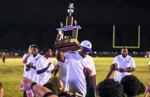 Columbia coach Brian Allen raises the Old Oaken Bucket trophy after his team defeated Suwannee 13-0 on Friday. (BRENT KUYKENDALL/Lake City Reporter)