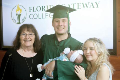 Ryan Appling holds his baby, Aubree, after graduating from Florida Gateway College on Thursday. Also pictured with Appling are Sherri Whitaker (left) and Lacee Ellis (right). (TONY BRITT/Lake City Reporter)