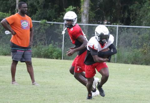 Fort White running back Keimarion Neal takes a handoff from quarterback Jayden Jackson during Thursday's practice. (MORGAN MCMULLEN/Lake City Reporter)