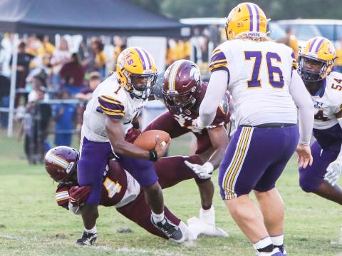 Columbia quarterback Zamarion Jones is bottled up by a pair of Coffee defenders on Friday night. (BRENT KUYKENDALL/Lake City Reporter)