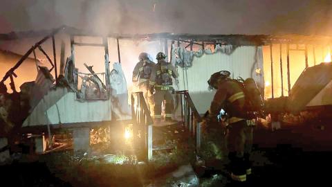 Live Oak firefighters make entry into a burning mobile home early Thursday morning on the south side of the city. Two mobile homes caught fire in the incident, but nobody was injured. (COURTESY LIVE OAK FIRE DEPARTMENT)