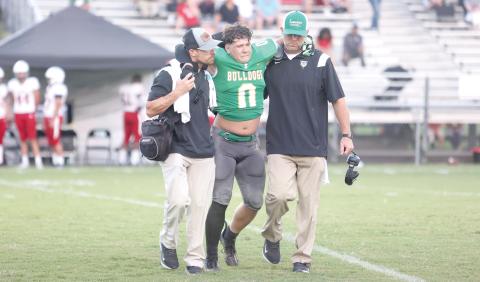 Suwannee linebacker Christian Socarras is helped off the field by the team trainer (left) and head coach Kyler Hall after injuring his knee during Friday’s Preseason Classic against Bishop Kenny. (PAUL BUCHANAN/Special to the Reporter)