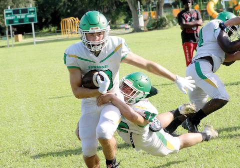 Suwannee receiver Koy Frier runs up the field for yardage as linebacker Christian Soccares dives for a tackle during an intrasquad scrimmage on Aug. 3. (JAMIE WACHTER/Lake City Reporter)