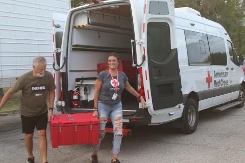 Red Cross workers unload hot meals out of an American Red Cross Emergency Response Vehicle on Monday evening at the Fort White Community Center. Red Cross served Shepherd's Pie and bread prepared by Big D's Barbecue in Tallahassee as dinner to people without power from Hurricane Helene. (TONY BRITT/Lake City Reporter)