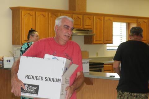 Carl Lynn carries his MREs and water out of the Fort White Community Center on Sunday afternoon. Lynn's biggest concern moving forward without power is for the welfare of his animals on his 30 acres in southern Columbia County. (STASI WACHTER/Lake City Reporter)