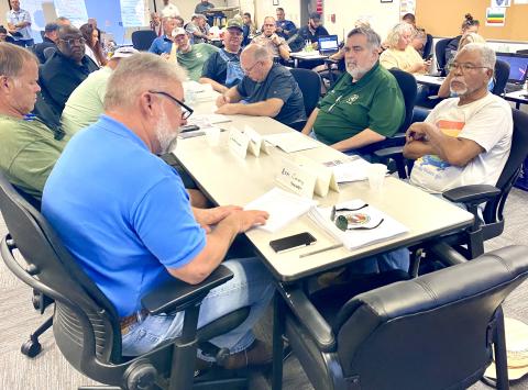 Assistant County Manager Kevin Kirby (left, blue shirt) gives a road debris cleanup report to county commissioners Saturday during the daily briefing at the Columbia County EOC bunker. (TODD WILSON/Lake City Reporter)
