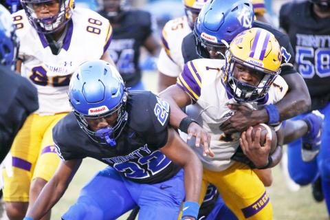 Columbia quarterback Zamarion Jones is tackled by Trinity Christian defensive back Kaleel Vereen on Friday. (BRENT KUYKENDALL/Lake City Reporter)