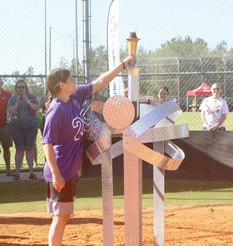 Columbia County athlete Rachel Saye places the torch into a stand during the opening ceremonies Saturday at the Southside Sports Complex. (TONY BRITT/Lake City Reporter)