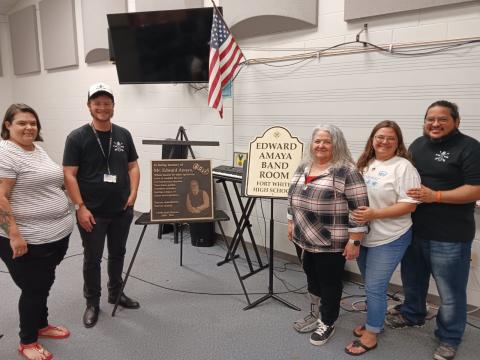 Heather Carraway (from left) stands with David Harris, Fort White High School band director, as they show a plaque and bandroom dedication placard for the late Ed Amaya. Amaya’s family members Peggy Amaya, Miranda Amaya-Firpo and Rafael Amaya-Firpo were also attended the program. (TONY BRITT/Lake City Reporter)
