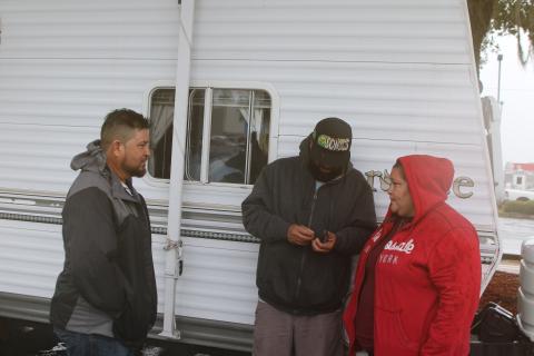 Amanda Ramirez (right) and her family members hold a conversation while their camper is parked in the Walmart parking lot. Ramirez and family evacuated from Manatee County a few days ago to avoid Hurricane Milton. (TONY BRITT/Lake City Reporter)