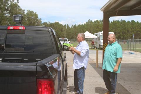 State Rep. Chuck Brannan (left) and Columbia County Commissioner Rocky Ford help pass out drinks and food to people mpacted by Hurricane Helene at the Fort White Community Center on Thursday. (TONY BRITT/Lake City Reporter)