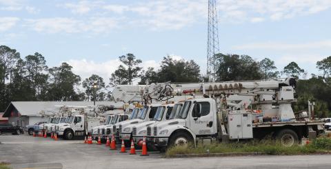 Power trucks line the former I-75 Autos site on Duval Street on Thursday, waiting to head south to help after Hurricane Milton. (JAMIE WACHTER/Lake City Reporter)