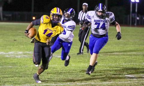 Columbia quarterback Xavier Collins scrambles up field away from the Ridgeview defense on Oct. 11. (BRENT KUYKENDALL/Lake City Reporter)