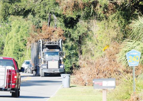 A storm debris removal contractor picks up debris along County Road 240 on Tuesday morning. The county’s efforts to clean up the record amount of debris from Hurricane Helene will be slowed by Hurricane Milton. (JAMIE WACHTER/Lake City Reporter)