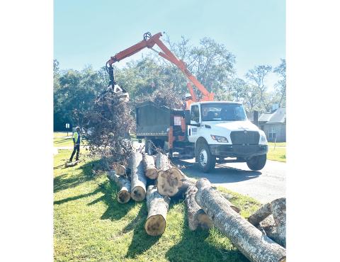 Contractor crews working for Ceres, and contracted with Columbia County to assist with the cleanup of storm debris following Hurricane Helene, pick up stacked debris in the right of way along NW Winding Way on the county’s west side last weekend. (TODD WILSON/Lake City Reporter)