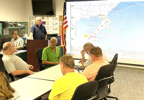 Shayne Morgan describes Hurricane Milton, which now is a Category 5. Seated clockwise from left are Rocky Ford, Ron Williams, Kevin Kirby and Robby Hollingsworth.  (TODD WILSON/Lake City Reporter)