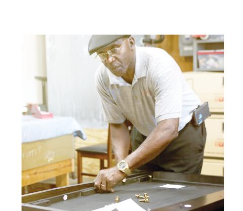 Robert Nelson, assembling a bed’s headboard, said the furniture has gotten heavier during the past five decades. (TONY BRITT/Lake City Reporter)