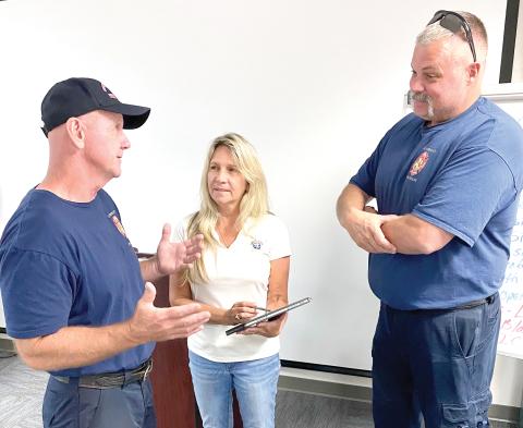 Columbia County Fire Chief Jeff Crawford (from left), Columbia County Sheriff’s Office employee Hope Crawford and Assistant Fire Chief Lance Hill discuss the rescue of Ken Stapleton, 66, of Fort White, who was pinned in his truck after a tree fell on it during the height of Hurricane Helene early Friday morning. (TODD WILSON/Lake City Reporter)
