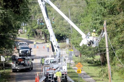 Linemen work on a power pole on SW Grandview Street in Lake City on Monday as utility crews continue to try to get power back to residents following Hurricane Helene. (TONY BRITT/Lake City Reporter)