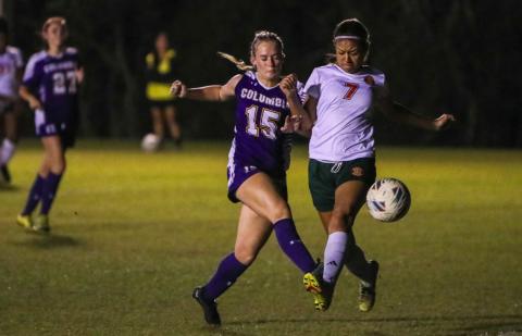 Columbia's Zoe Bulock (15) gets a shot off while tightly defended by Eastside's Kikyo Johnson (7) during Tuesday's match. (BRENT KUYKENDALL/Lake City Reporter)