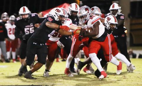 Fort White linebacker Lecosta Byrd (0) goes to wrap up Red Devils running back Jamari Williams Friday at Arrowhead Stadium. (BRENT KUYKENDALL/Lake City Reporter)