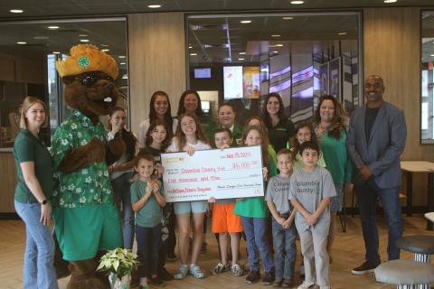 Columbia County Extension Service employees, Bellamy Beaver and youngsters in the local 4H program stand with McDonald’s officials during a check presentation on Tuesday afternoon. (TONY BRITT/Lake City Reporter)