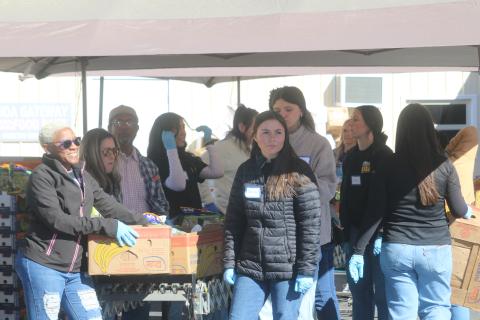 Xavier White (left) and Taylor Carroll wait for a client from Catholic Charities to park their vehicle so they can unload boxes of food into the car. Catholic Charities served approximately 650 people during this year’s Thanksgiving food distribution. (TONY BRITT/Lake City Reporter)