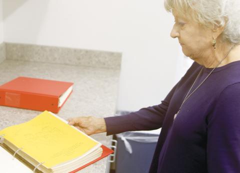Mary Loughran, the daughter of Mary Ethel Anderson, looks through a binder containing some of the ‘Goodie Books’ that her mother created as a county extension service agent. (TONY BRITT/Lake City Reporter)