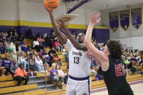 Columbia forward Zavian Douglas scores while defended by The Rock forward Hendrix Loughridge on Tuesday night. (JORDAN KROEGER/Lake City Reporter)