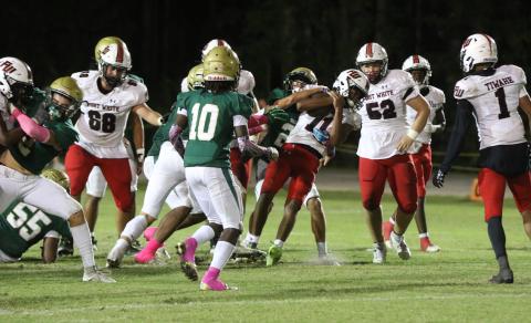 Fort White quarterback Gavin Peterson is dragged backward on a scramble attempt Friday night at Fleming Island. (MORGAN MCMULLEN/Lake City Reporter)