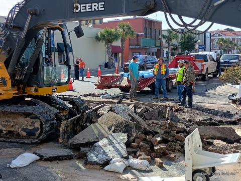 A construction crew takes in the scene above a  ruptured water main in downtown Live Oak. (ROB WOLFE/Lake City Reporter)