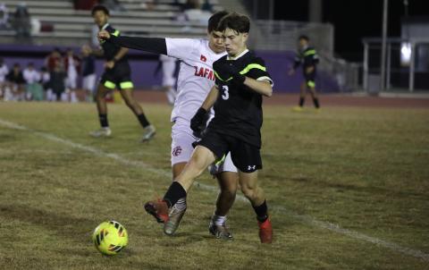 Columbia's Cody Bass passes while defended by Lafayette's Emiliano Tovar on Monday night. (BRENT KUYKENDALL/Lake City Reporter)