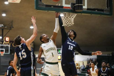FGC guard Omar'ion Brown drives between Santa Fe guard Ryan Webster (15) and Santa Fe forward Keylson Turner (10) for a layup on Thursday night. (BRENT KUYKENDALL/Lake City Reporter)