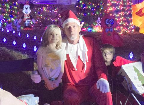 Rocky the Elf is pictured with Evangeline and Rowan McKenna during the special Christmas parade organized for Evangeline, who has been battling cancer for five years. (MONJA SLATER/Lake City Reporter)