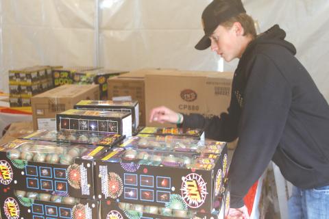 Landon Harper conducts an inventory count on fireworks at the Columbia FFA program’s  fireworks tent. (TONY BRITT/Lake City Reporter)